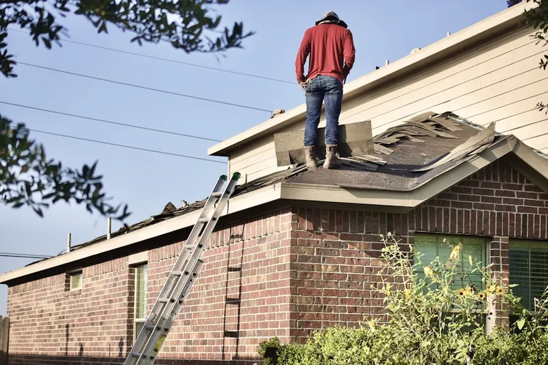 Professional roofer working on a residential roof in Harbor Gateway